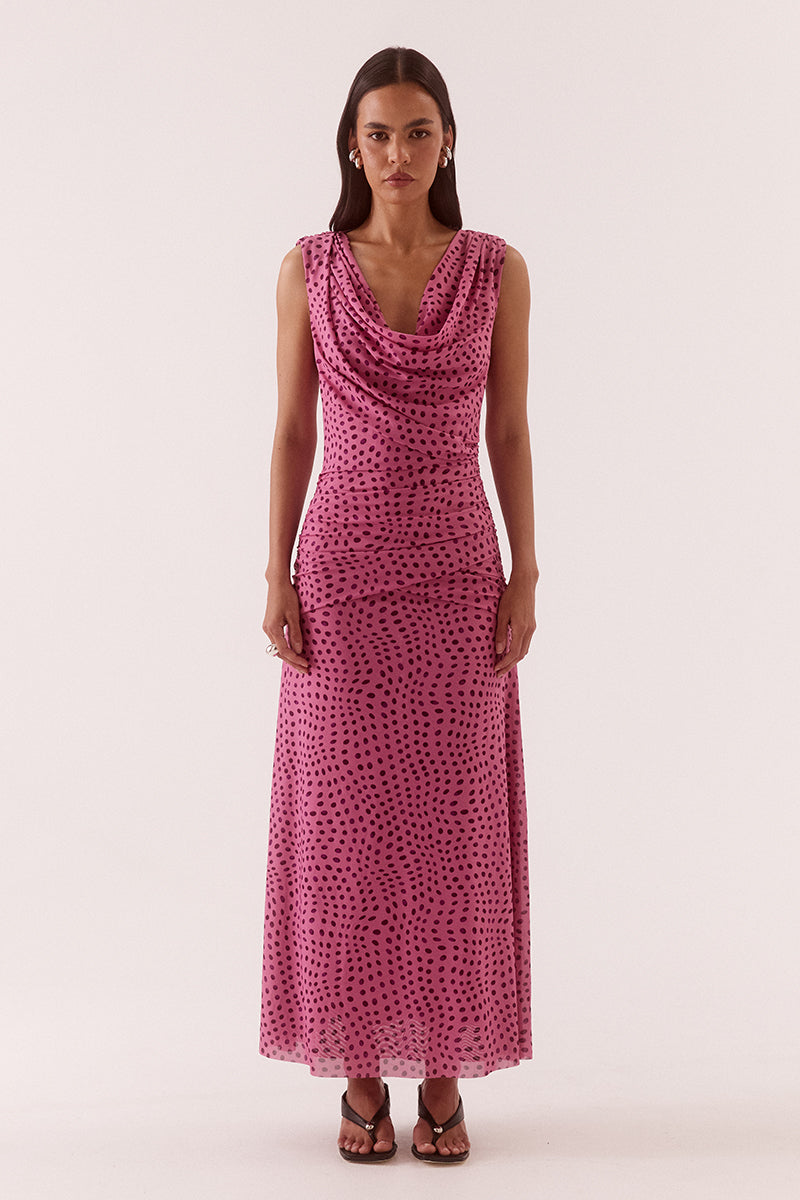 Model wearing an exclusive print sleeveless maxi dress with front and back cowl neckline, crossover gathered hip panels, and A-line skirt.