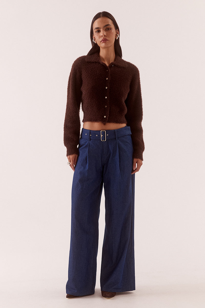 Model wearing a fluffy knit cardigan with collar, short buttoned front, long sleeves, dropped shoulders and fitted ribbed hem and cuffs.
