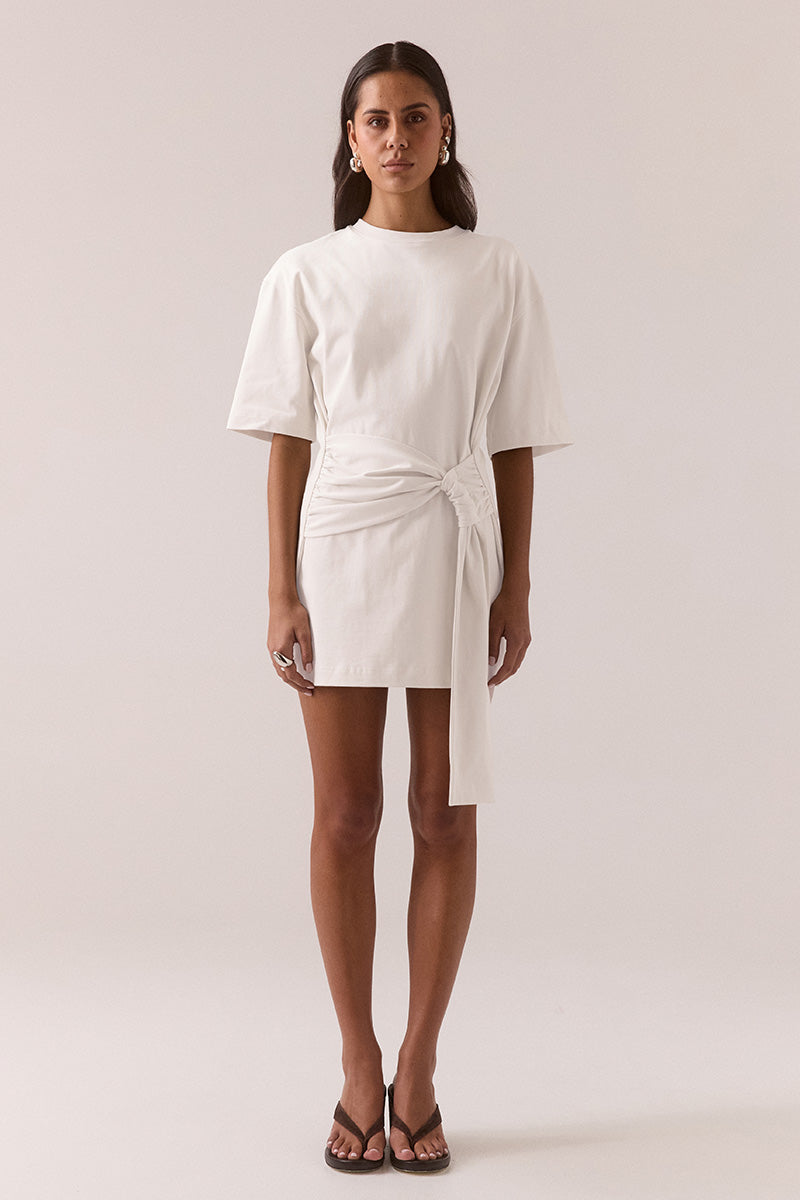 Relaxed fit 100% cotton mini T-shirt dress with crew neckline, dropped shoulders, side-gathered sash with loop detail, worn by model in size 8.