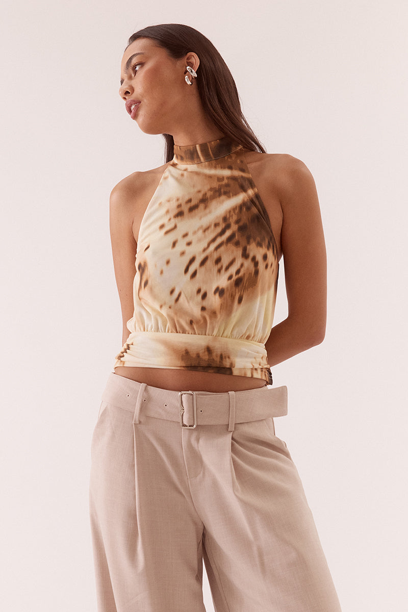 Women’s halter neck stretch mesh top with exclusive print, high neck collar, bloused bodice, gathered waistband, and back keyhole button closure.