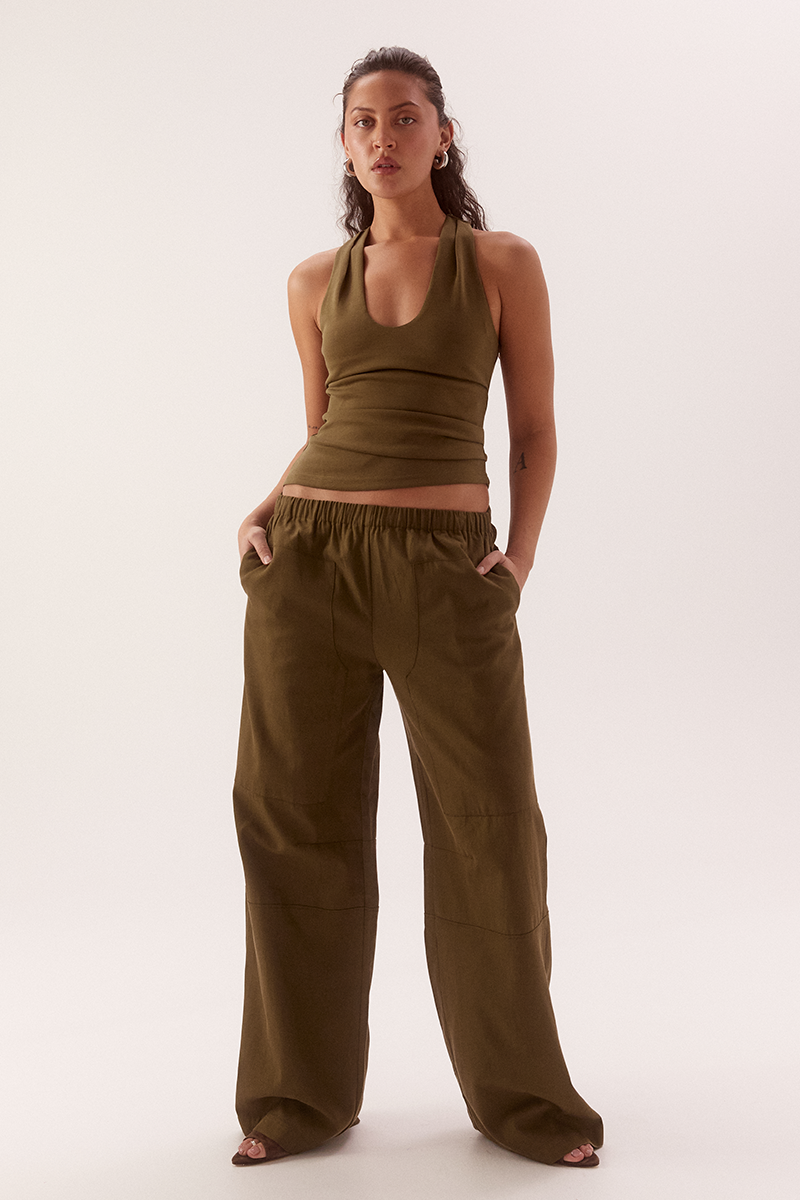 Women's viscose blend sleeveless top with deep scoop neckline, racer back, shoulder tucks, asymmetric hem and stretch lining.
