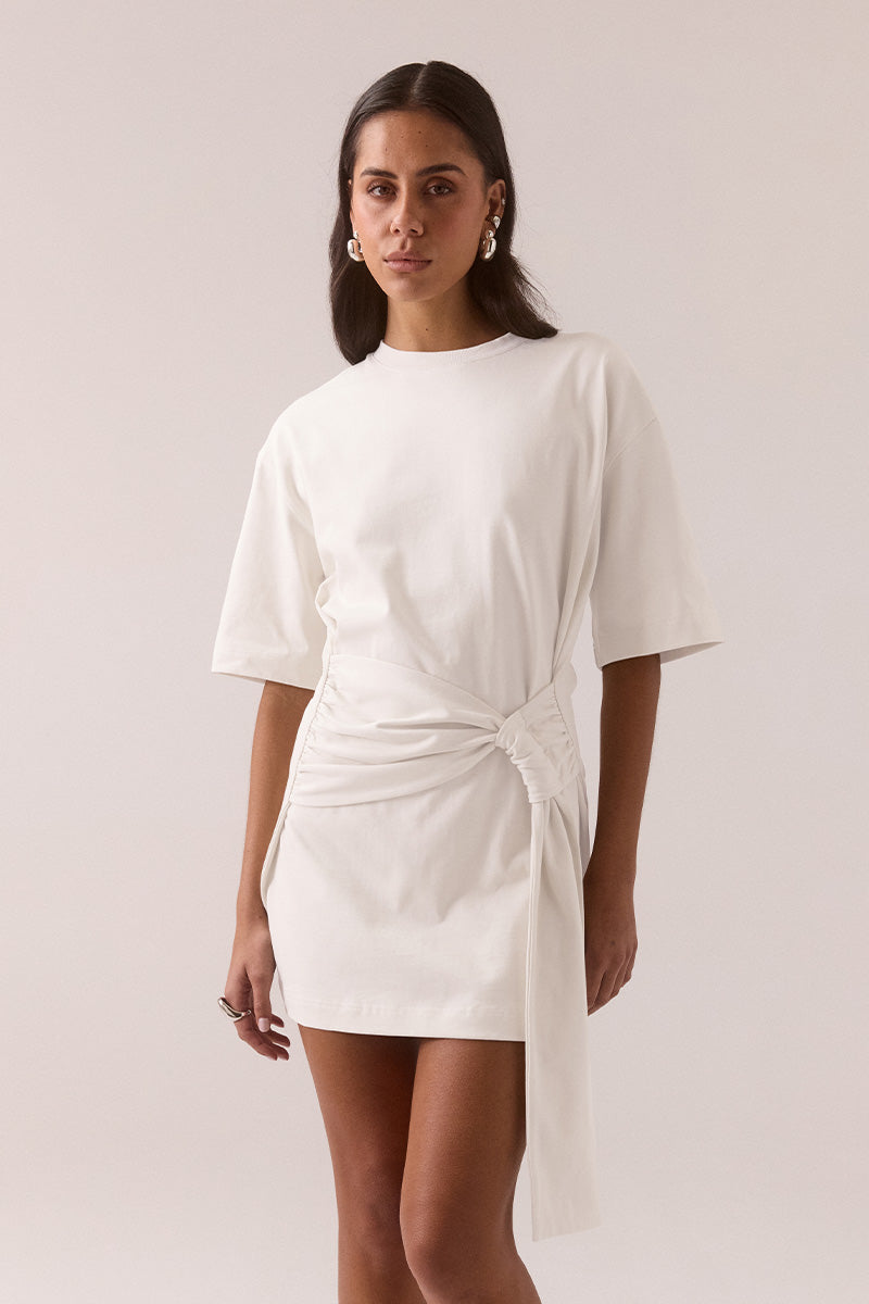 Relaxed fit 100% cotton mini T-shirt dress with crew neckline, dropped shoulders, side-gathered sash with loop detail, worn by model in size 8.