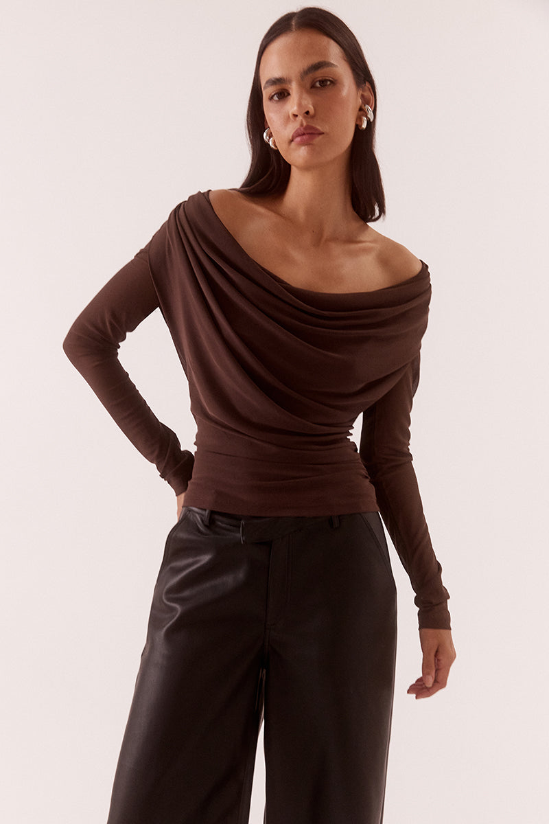 Model wearing a stretch mesh long sleeve top with deep cowl front and back neckline, gathered waist, shoulder tucks and fitted silhouette.