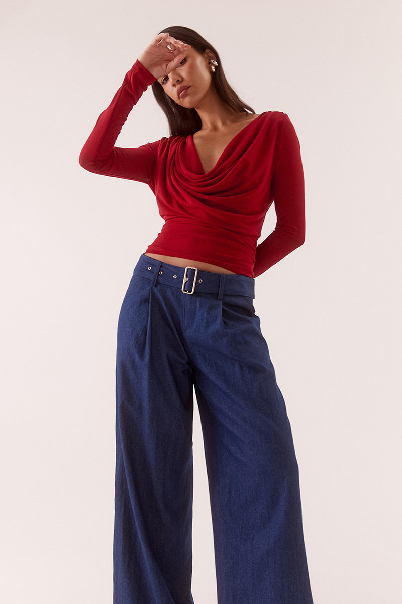 Model wearing a stretch mesh long sleeve top with deep cowl front and back neckline, gathered waist, shoulder tucks and fitted silhouette.