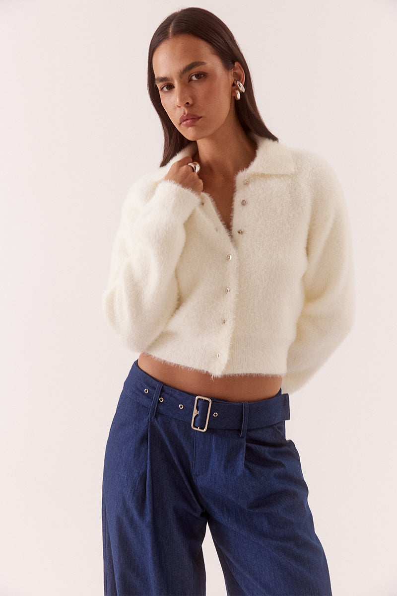 Model wearing a fluffy knit cardigan with collar, short buttoned front, long sleeves, dropped shoulders and fitted ribbed hem and cuffs.