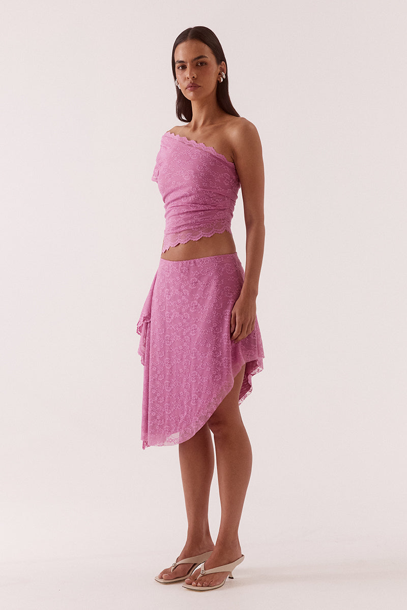 Model wearing a stretch lace one shoulder top with scalloped neckline, asymmetric hem and waist tuck detailing in a fitted silhouette.