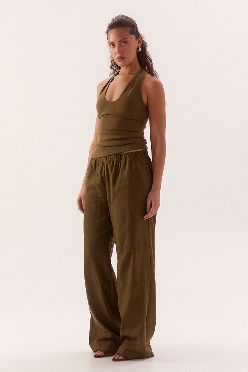 Women's viscose blend sleeveless top with deep scoop neckline, racer back, shoulder tucks, asymmetric hem and stretch lining.