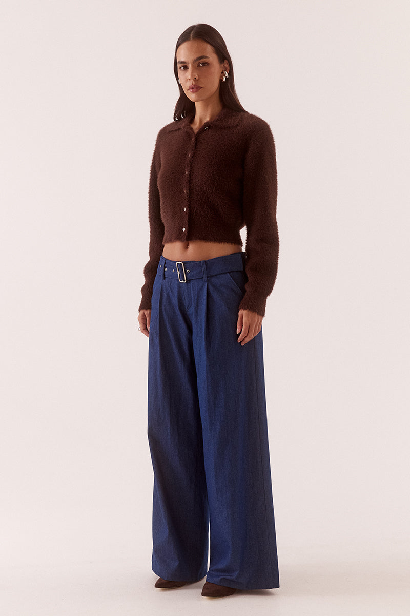 Model wearing a fluffy knit cardigan with collar, short buttoned front, long sleeves, dropped shoulders and fitted ribbed hem and cuffs.