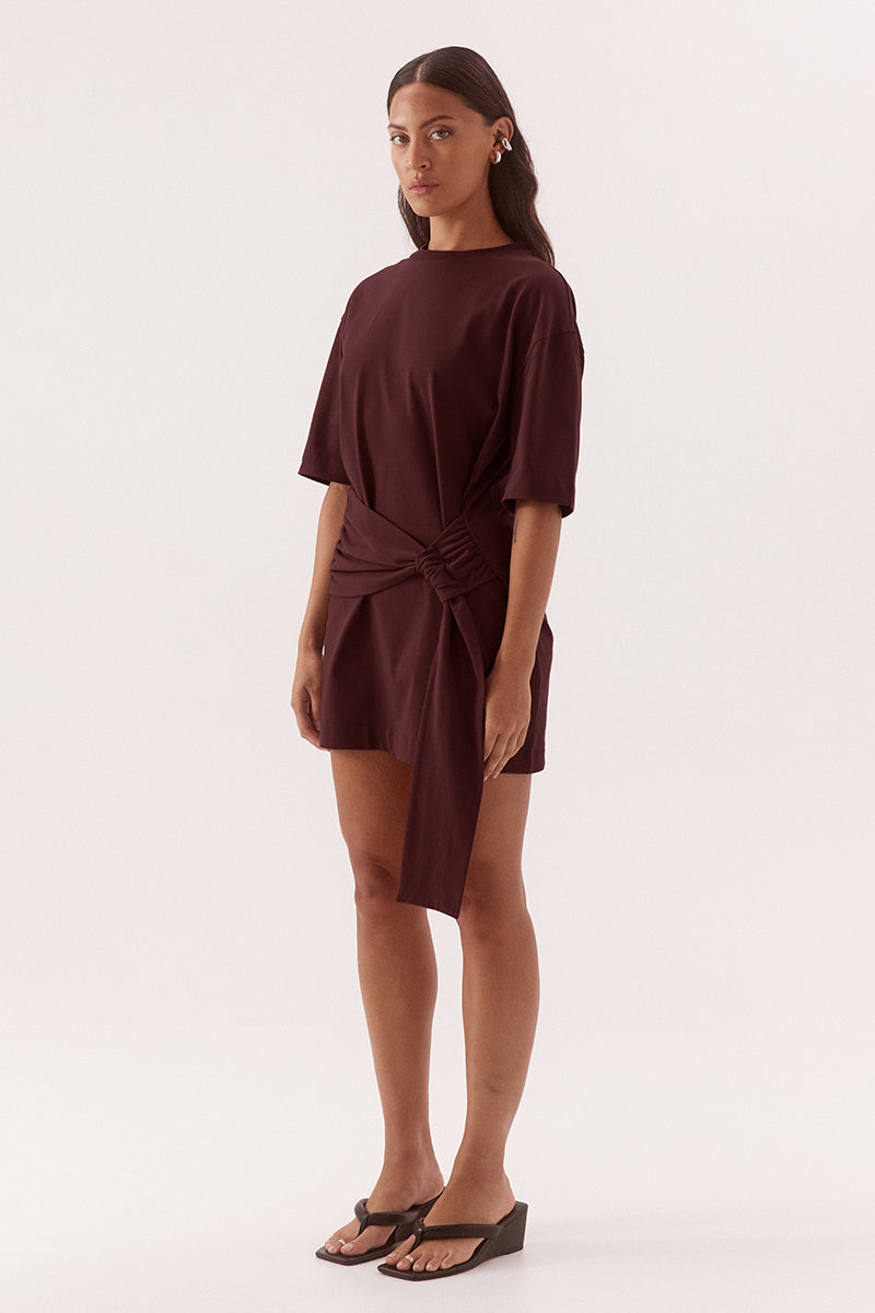 Relaxed fit 100% cotton mini T-shirt dress with crew neckline, dropped shoulders, side-gathered sash with loop detail, worn by model in size 8.