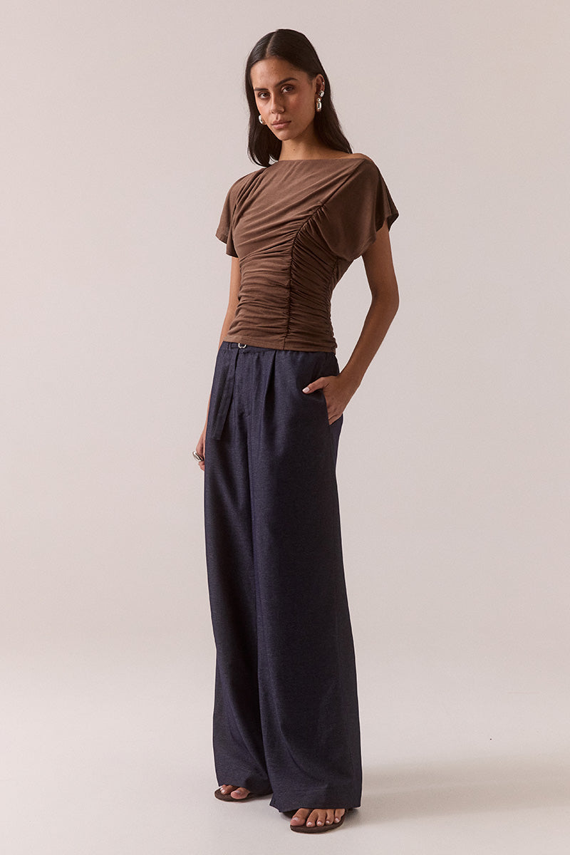 Model wearing slinky modal blend top with off-shoulder neckline option, asymmetric sleeve with split detail, gathered side seam, fully lined body-skimming fit.