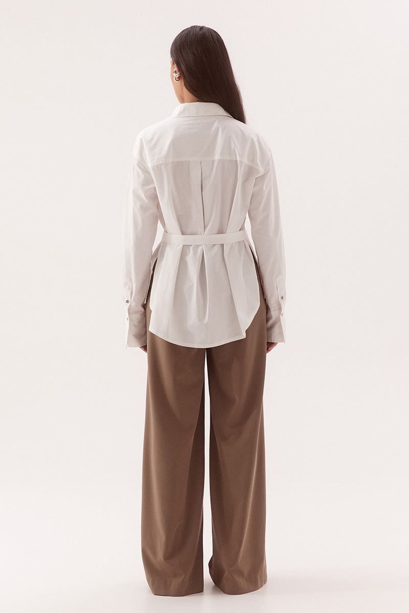 Women's relaxed fit cotton long sleeve shirt with dropped shoulders, silver metal buttons, adjustable belt detail, and side split shirtmaker hem.