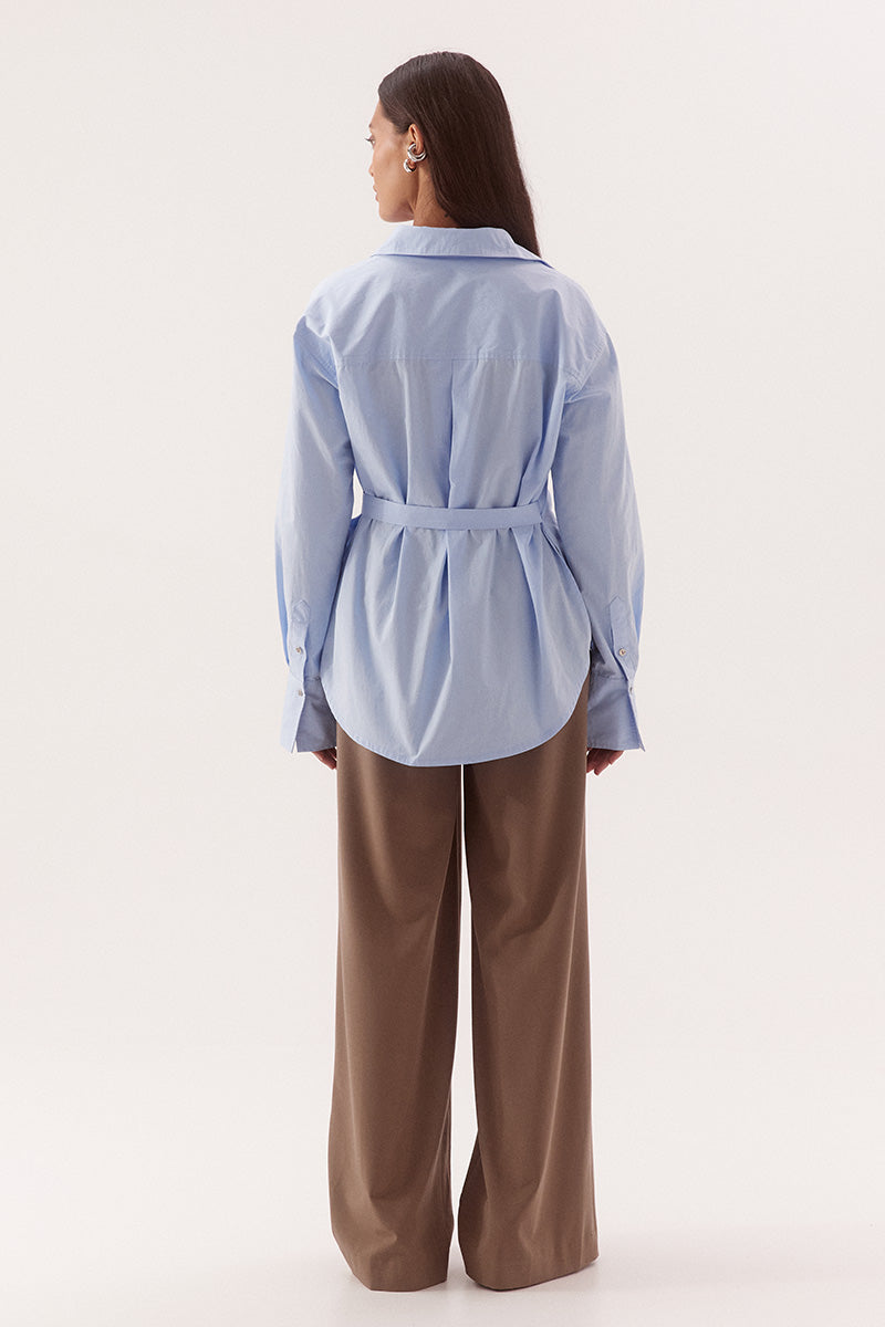 Women's relaxed fit cotton long sleeve shirt with dropped shoulders, silver metal buttons, adjustable belt detail, and side split shirtmaker hem.