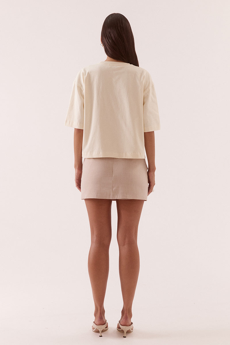 Women’s oversized cotton tee with dropped shoulders, crew neck, mid-length sleeves, and tucked front detail creating a shaped hem.