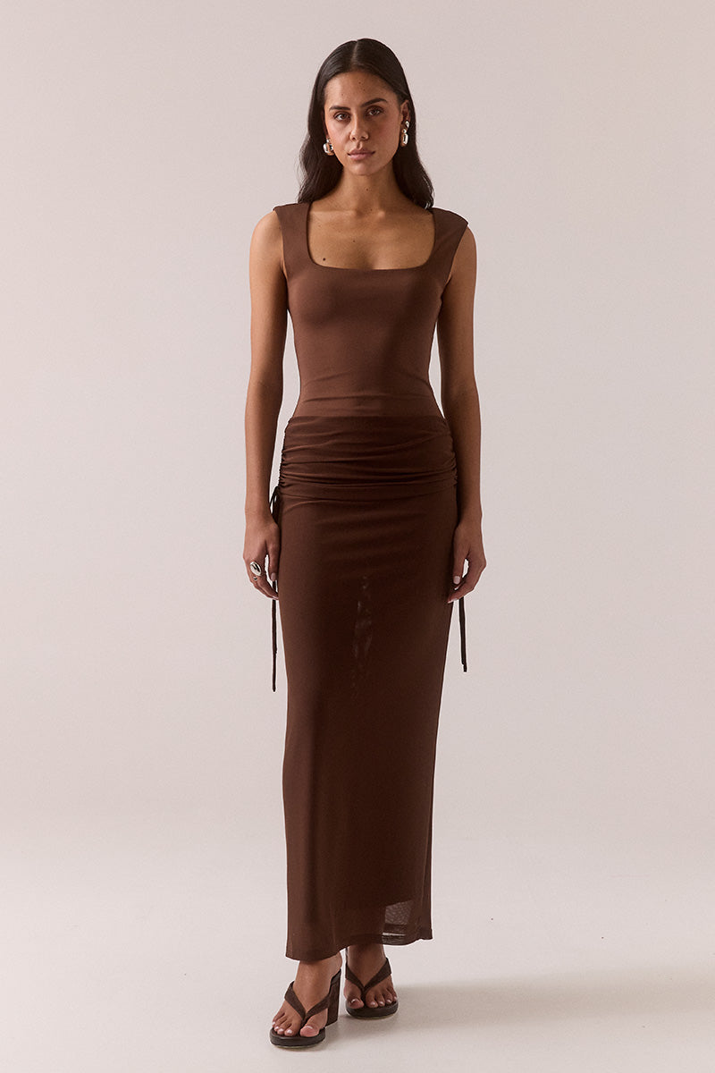 Model wearing stretch mesh two-piece maxi dress with halter neck top, long sleeve bolero, scoop neckline, built-in bralette support, side ruching, and fully lined non-sheer body-contouring fit.