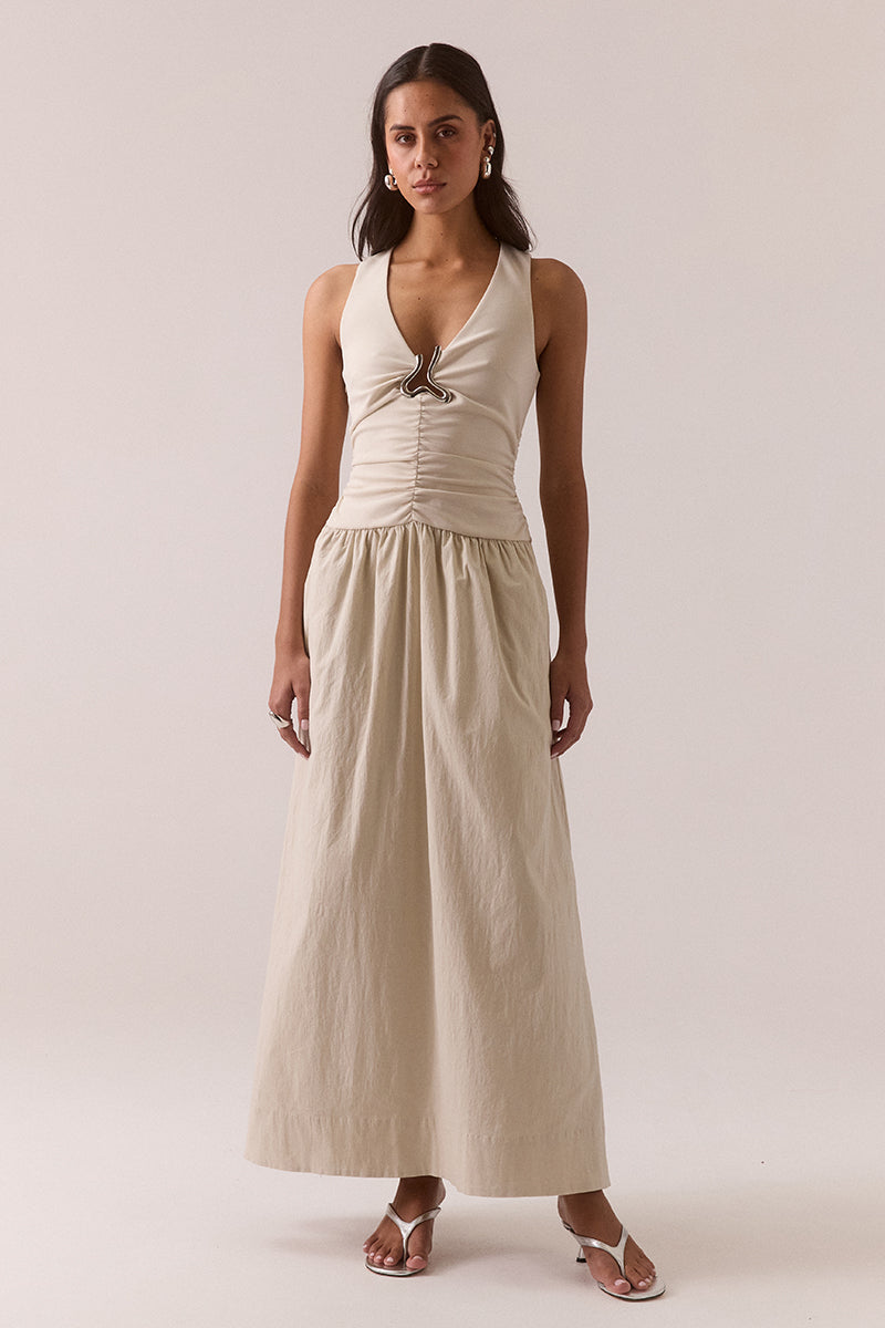 Sleeveless V-neck maxi dress in stretchy fabric with fitted bodice, full skirt, silver chest hardware, elasticated dropped waist and racer back, worn by model in size 8.