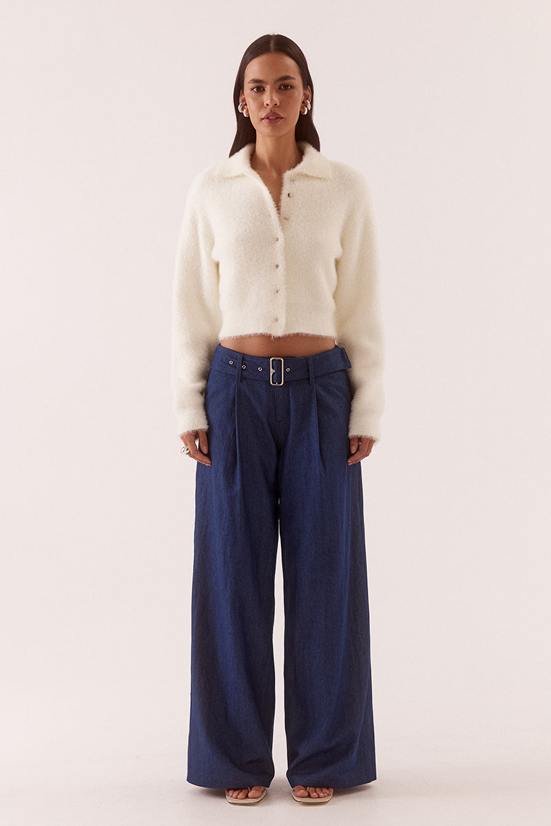 Model wearing a fluffy knit cardigan with collar, short buttoned front, long sleeves, dropped shoulders and fitted ribbed hem and cuffs.