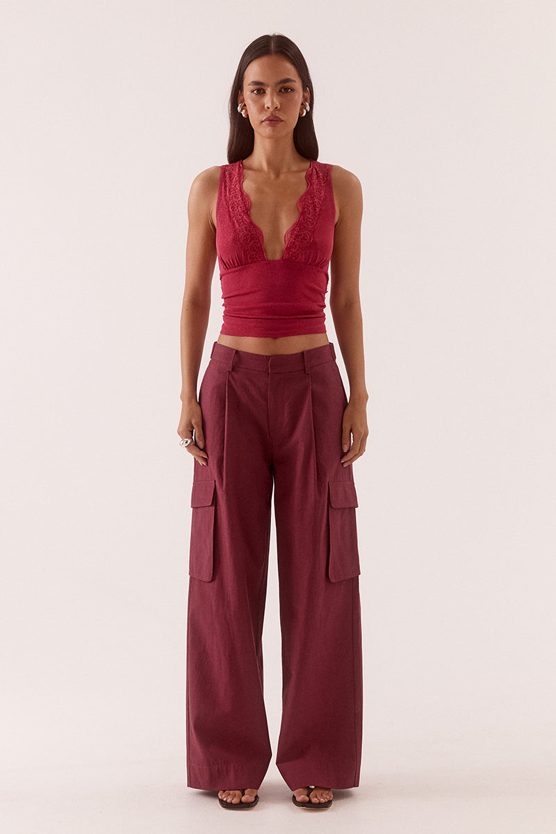 Textured stretch mesh sleeveless top with deep plunging neckline, lace trim, empire waist, and gathered front detail.