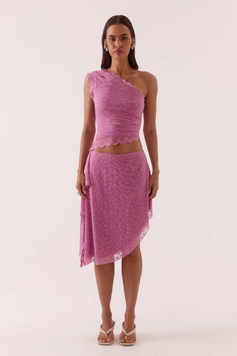 Model wearing a stretch lace one shoulder top with scalloped neckline, asymmetric hem and waist tuck detailing in a fitted silhouette.
