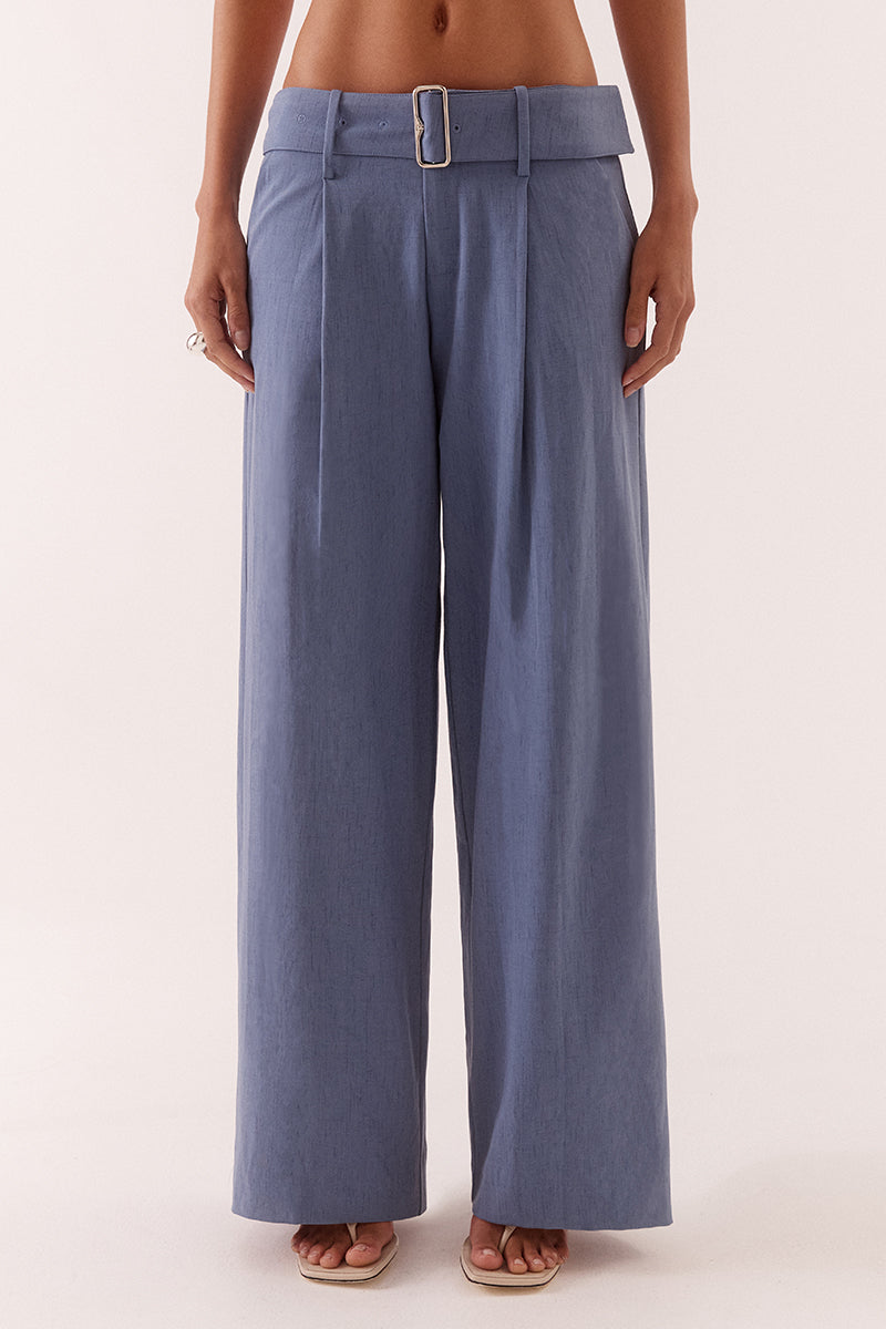 Women’s mid-rise wide leg pants in stretch rayon blend with front tucks, removable belt, angled pockets, and tailored fit with fly closure.