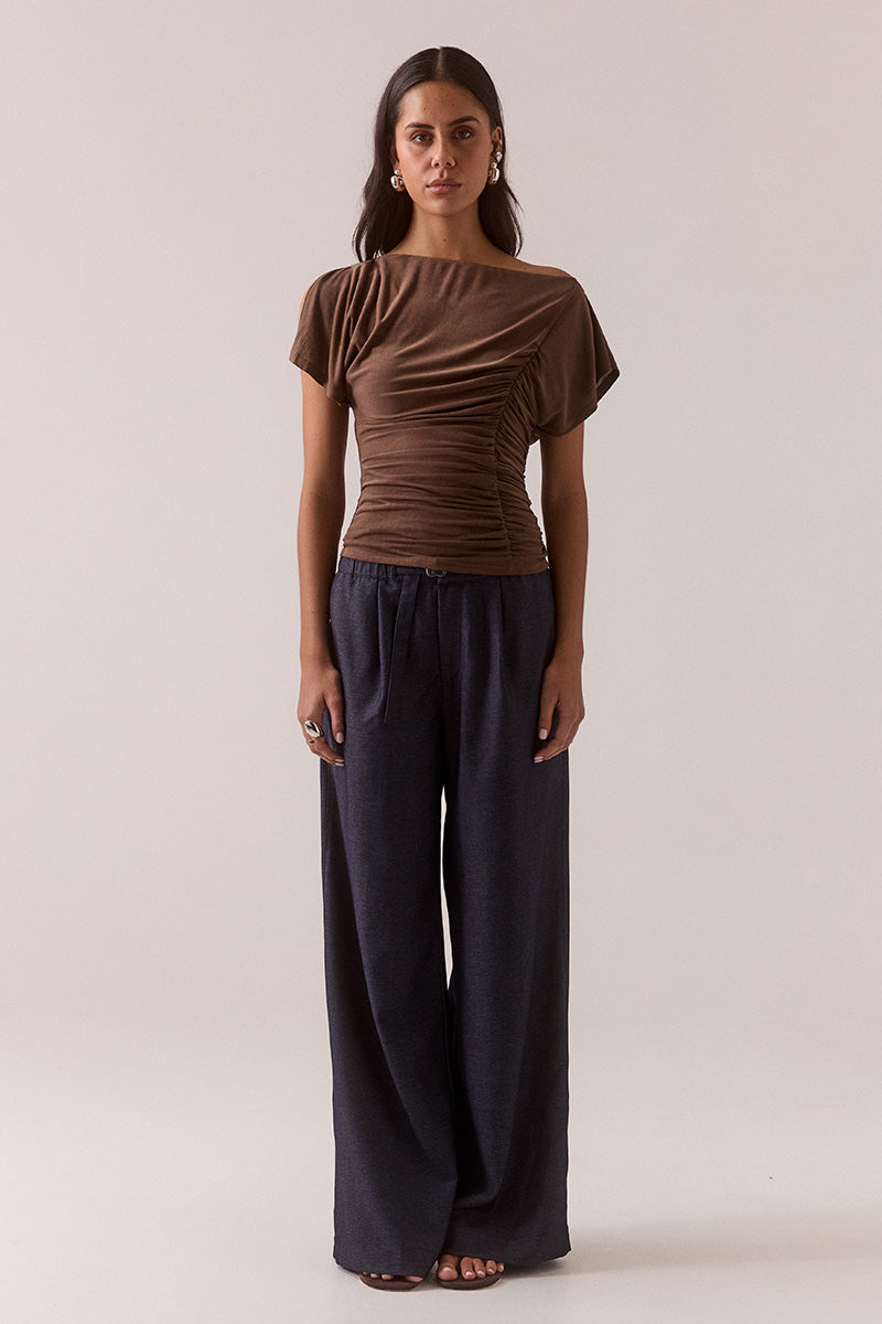 Model wearing slinky modal blend top with off-shoulder neckline option, asymmetric sleeve with split detail, gathered side seam, fully lined body-skimming fit.