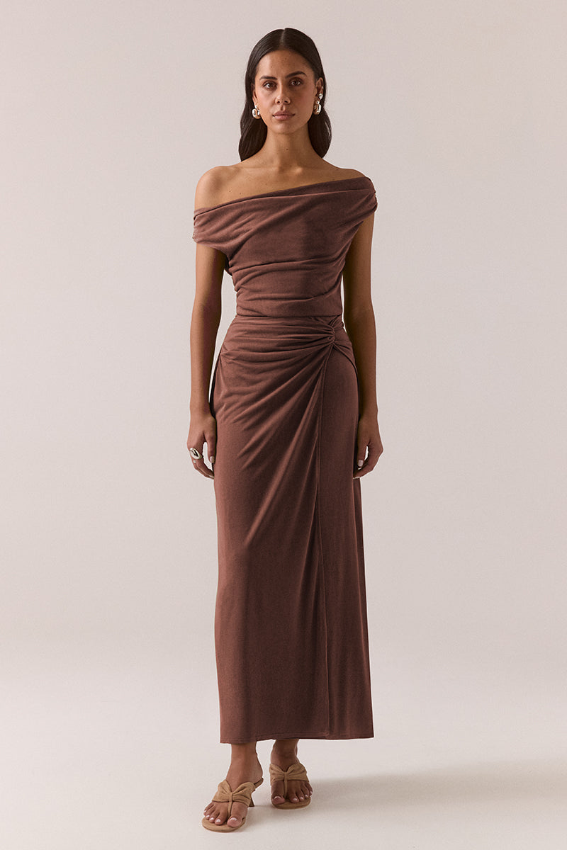 Stretch modal blend midi dress with front and back cowl necklines, off-shoulder styling, gathered shoulders and hips, loop tie overlayer skirt and left side split, worn by model in size 8.