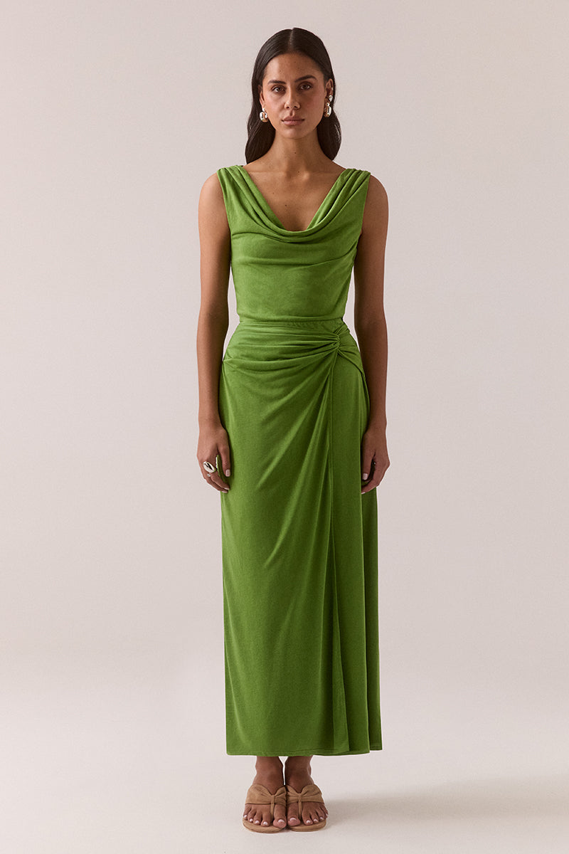 Stretch modal blend midi dress with front and back cowl necklines, off-shoulder styling, gathered shoulders and hips, loop tie overlayer skirt and left side split, worn by model in size 8.