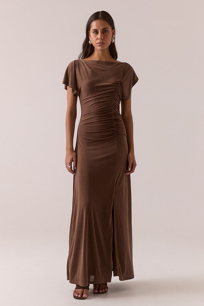 Model wearing slinky modal blend maxi dress with off-shoulder neckline option, asymmetric sleeve with split detail, gathered side seam, front hem split, and fully lined body-skimming silhouette.