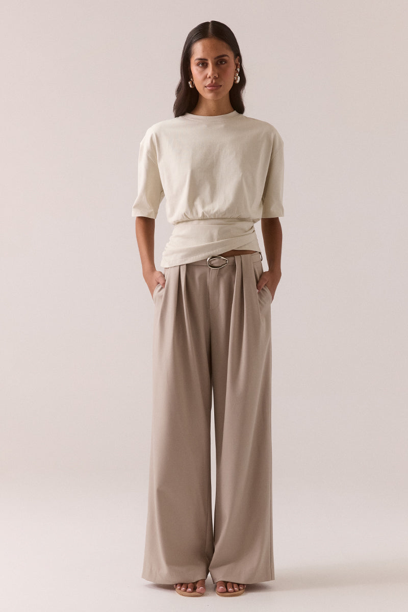 Relaxed fit 100% cotton T-shirt with crew neckline, dropped shoulders, asymmetrical drape hem layer and side invisible zipper, worn by model in size 8.