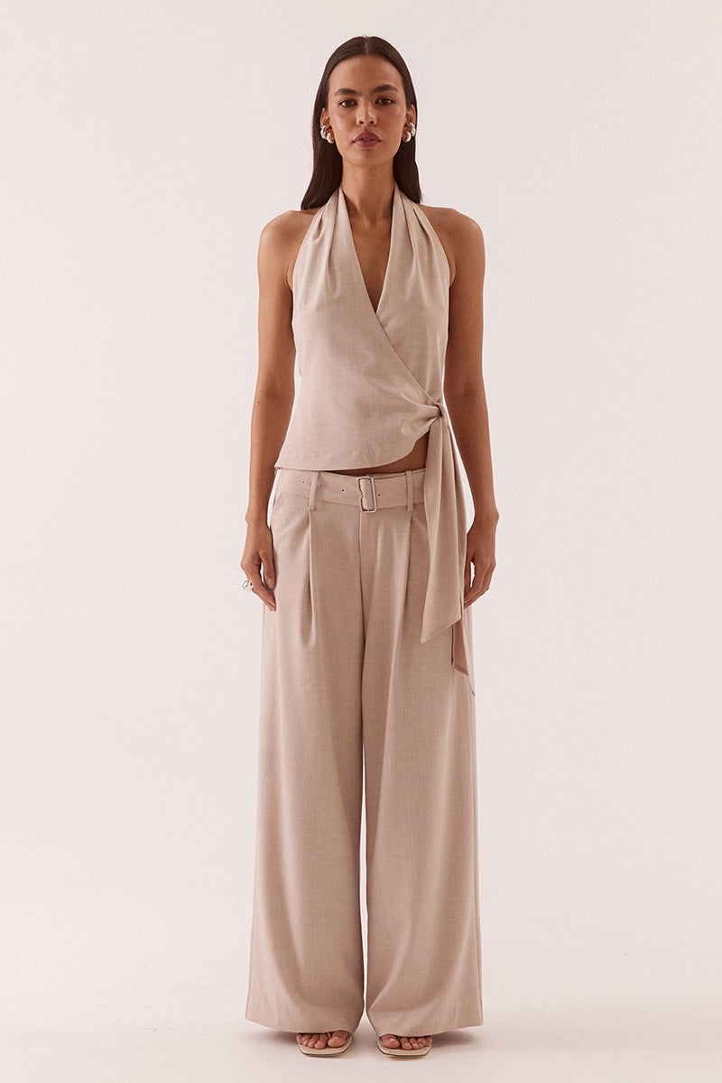 Women’s halter neck top in stretch rayon blend with wrap design, asymmetric hem, sash detail, elasticated back, and side zip closure.