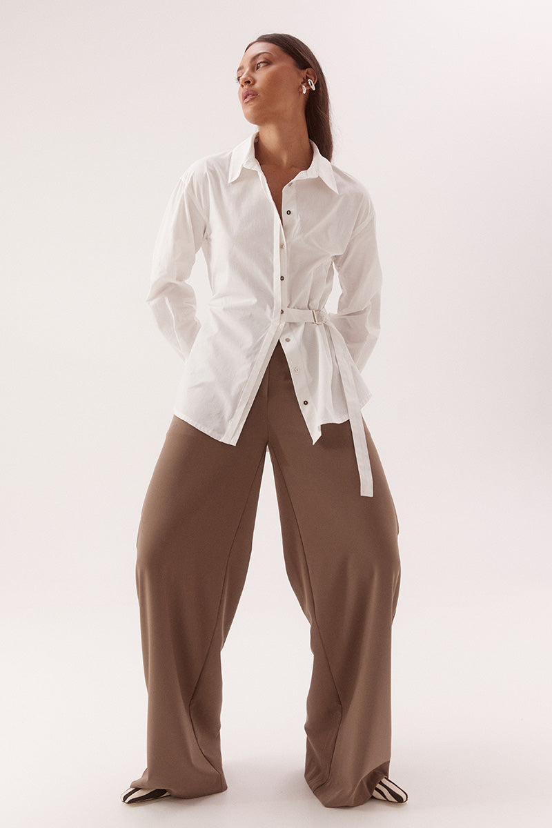 Women's relaxed fit cotton long sleeve shirt with dropped shoulders, silver metal buttons, adjustable belt detail, and side split shirtmaker hem.
