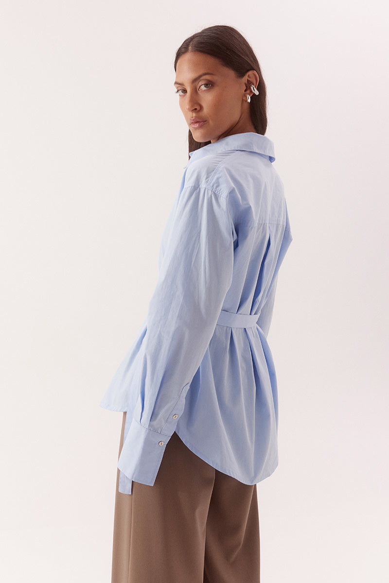 Women's relaxed fit cotton long sleeve shirt with dropped shoulders, silver metal buttons, adjustable belt detail, and side split shirtmaker hem.