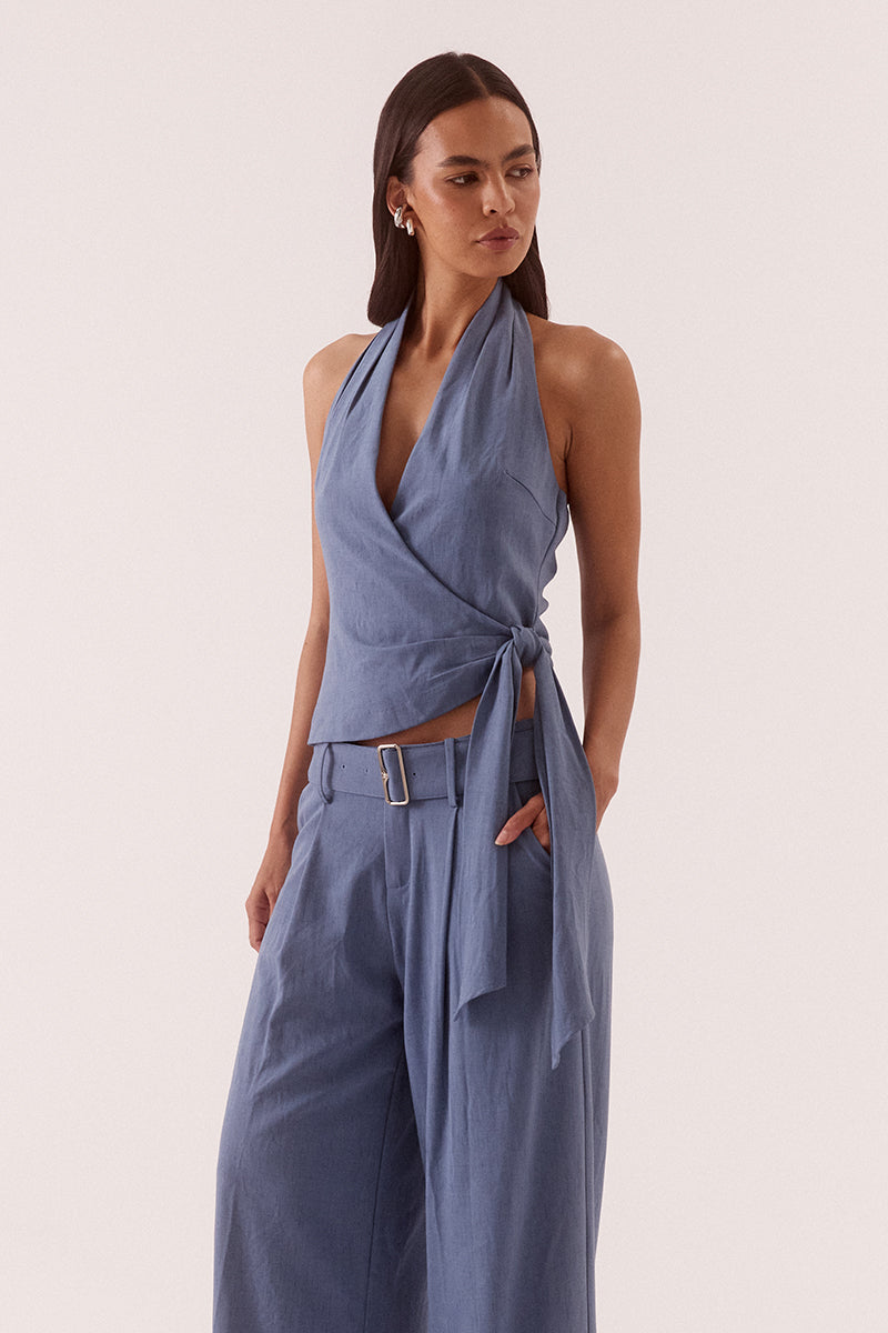 Women’s halter neck top in stretch rayon blend with wrap design, asymmetric hem, sash detail, elasticated back, and side zip closure.