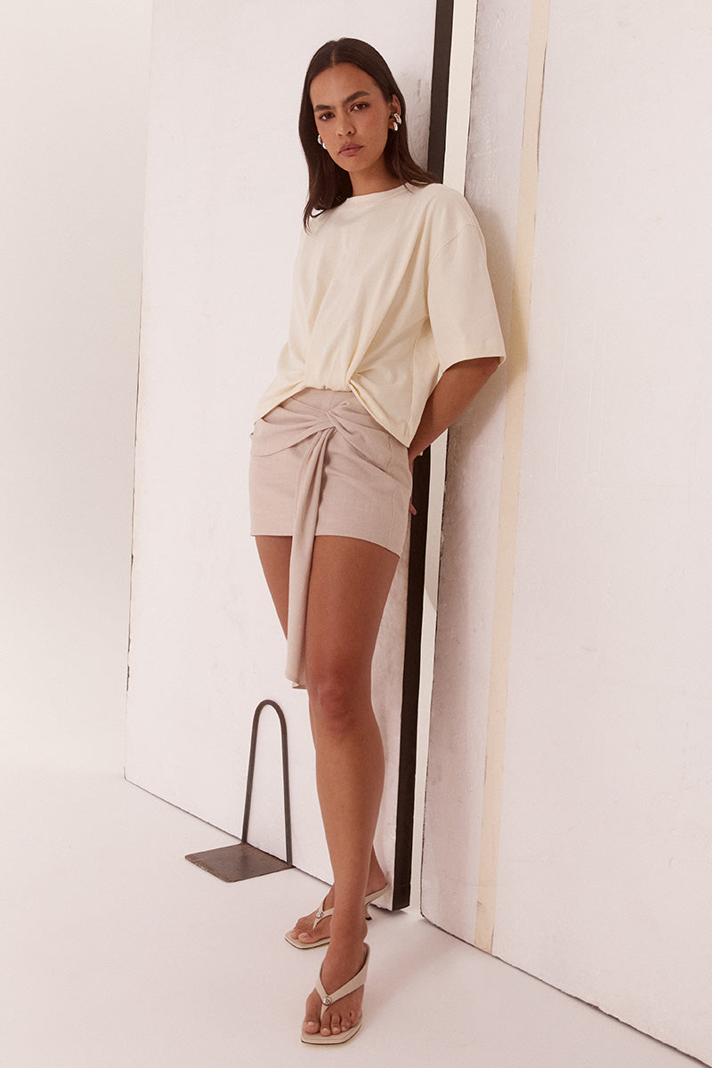 Women’s oversized cotton tee with dropped shoulders, crew neck, mid-length sleeves, and tucked front detail creating a shaped hem.