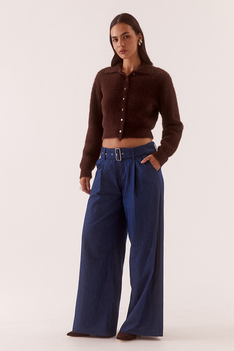 Model wearing a fluffy knit cardigan with collar, short buttoned front, long sleeves, dropped shoulders and fitted ribbed hem and cuffs.