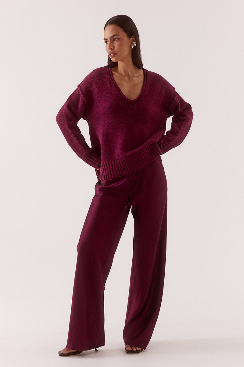 Women’s boxy knit sweater with plunging V-neckline, dropped shoulders, wide ribbed cuffs, and side split hem detail.