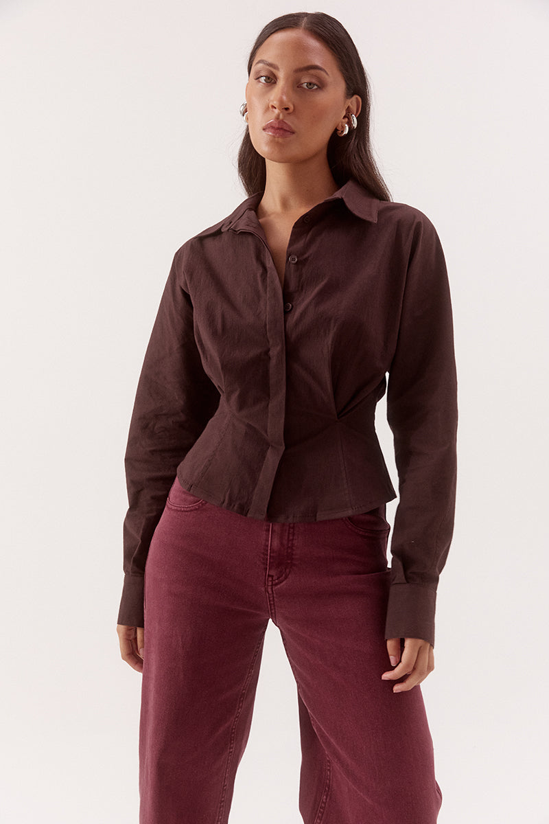 Women's cotton blend long sleeve shirt with a cinched waist, barrel sleeves, concealed button front, two-piece collar, and shaping seam details.