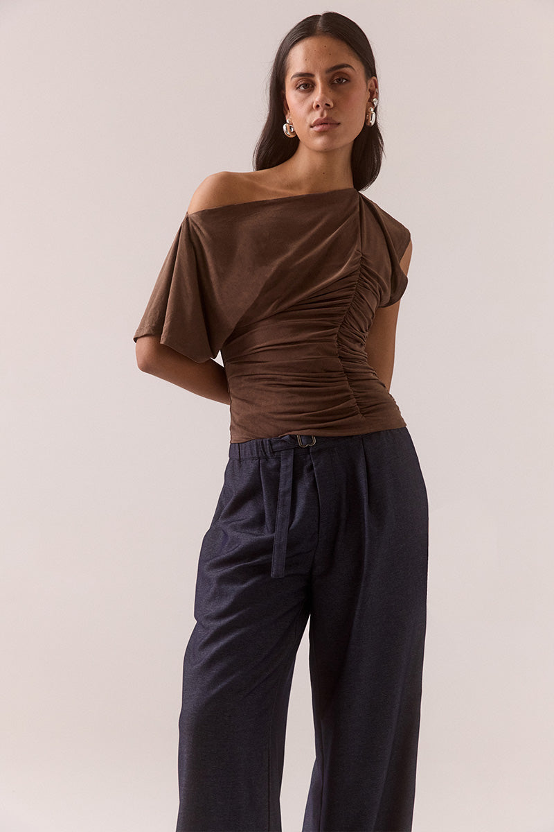 Model wearing slinky modal blend top with off-shoulder neckline option, asymmetric sleeve with split detail, gathered side seam, fully lined body-skimming fit.