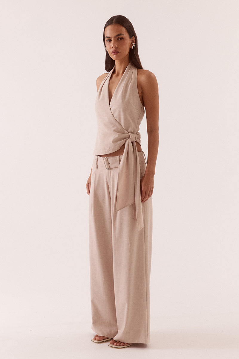 Women’s halter neck top in stretch rayon blend with wrap design, asymmetric hem, sash detail, elasticated back, and side zip closure.