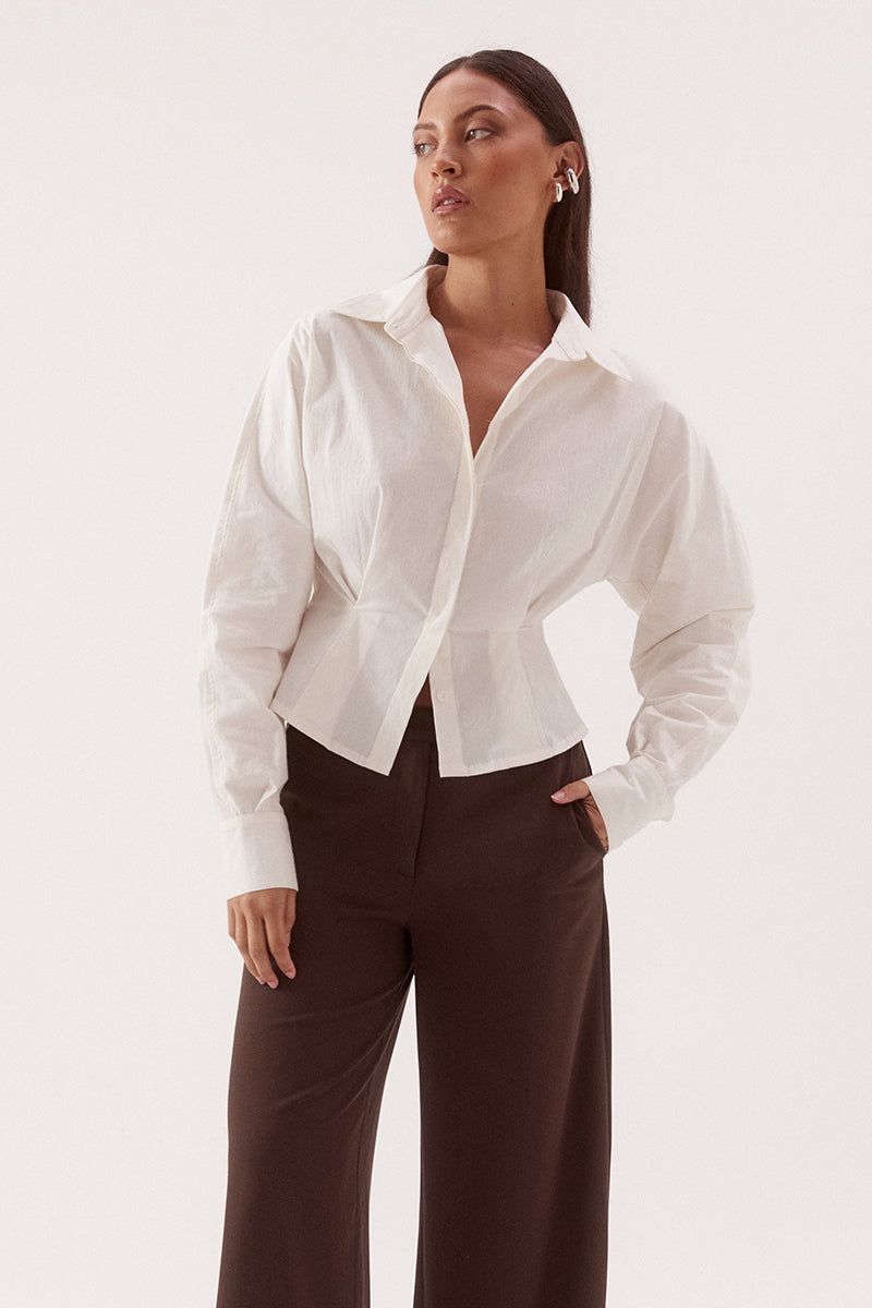 Women's cotton blend long sleeve shirt with a cinched waist, barrel sleeves, concealed button front, two-piece collar, and shaping seam details.