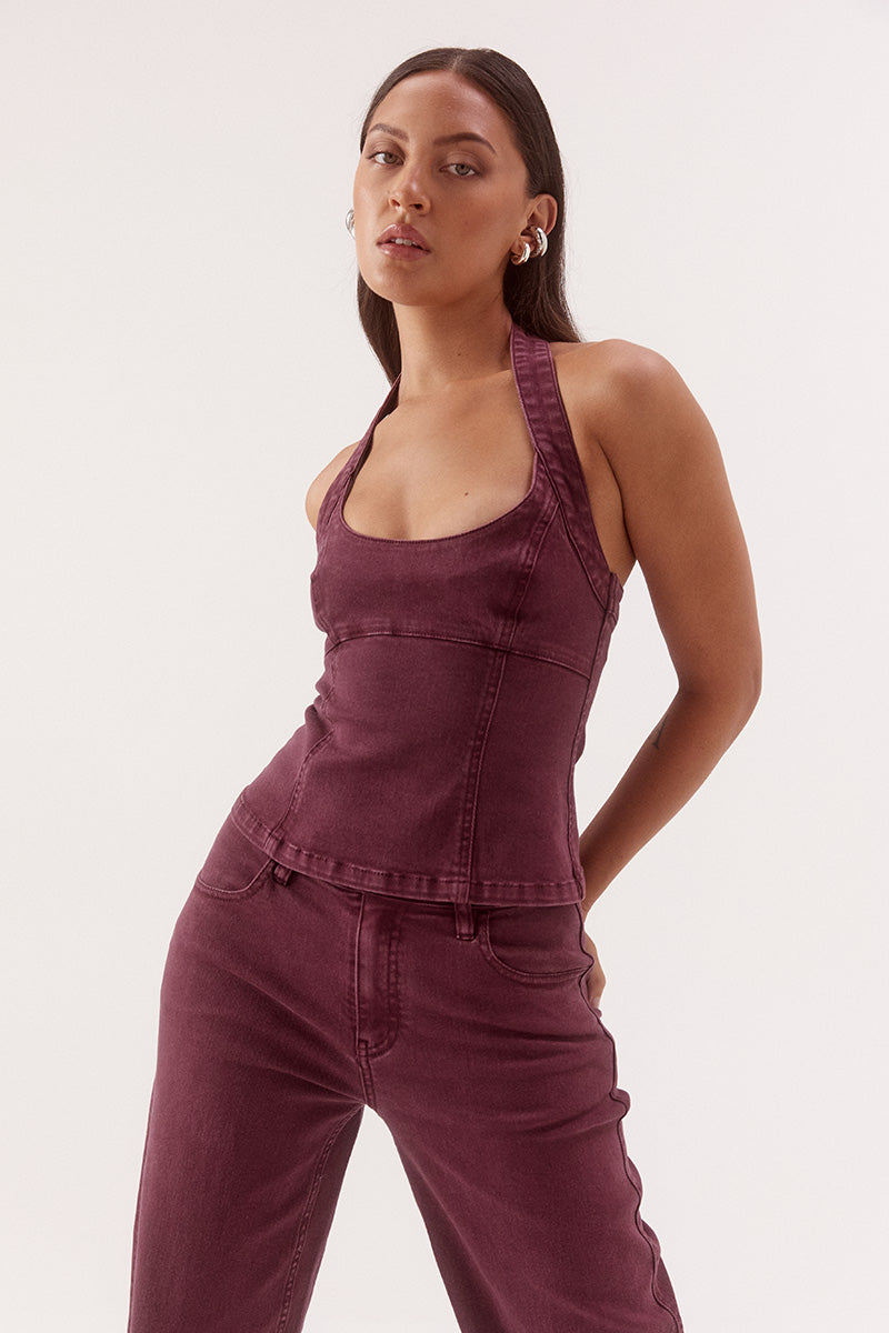 Women's cotton blend denim halter mini dress with scoop neckline, empire waist, princess seam detailing, and open-back zip closure.