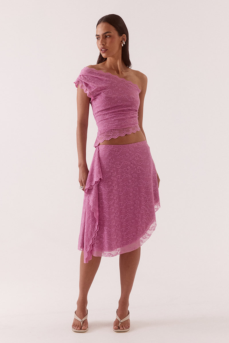 Model wearing a stretch lace one shoulder top with scalloped neckline, asymmetric hem and waist tuck detailing in a fitted silhouette.