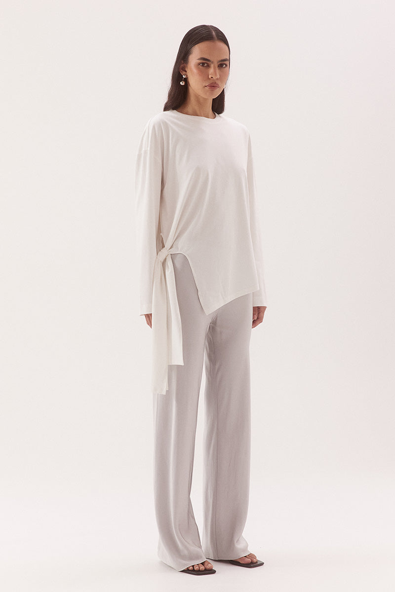 Women's oversized long sleeve cotton tee with dropped shoulders, crew neck, tie-side detail, and relaxed fit. Model wears size 8 and is 178cm tall.