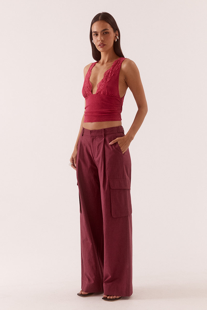 Textured stretch mesh sleeveless top with deep plunging neckline, lace trim, empire waist, and gathered front detail.