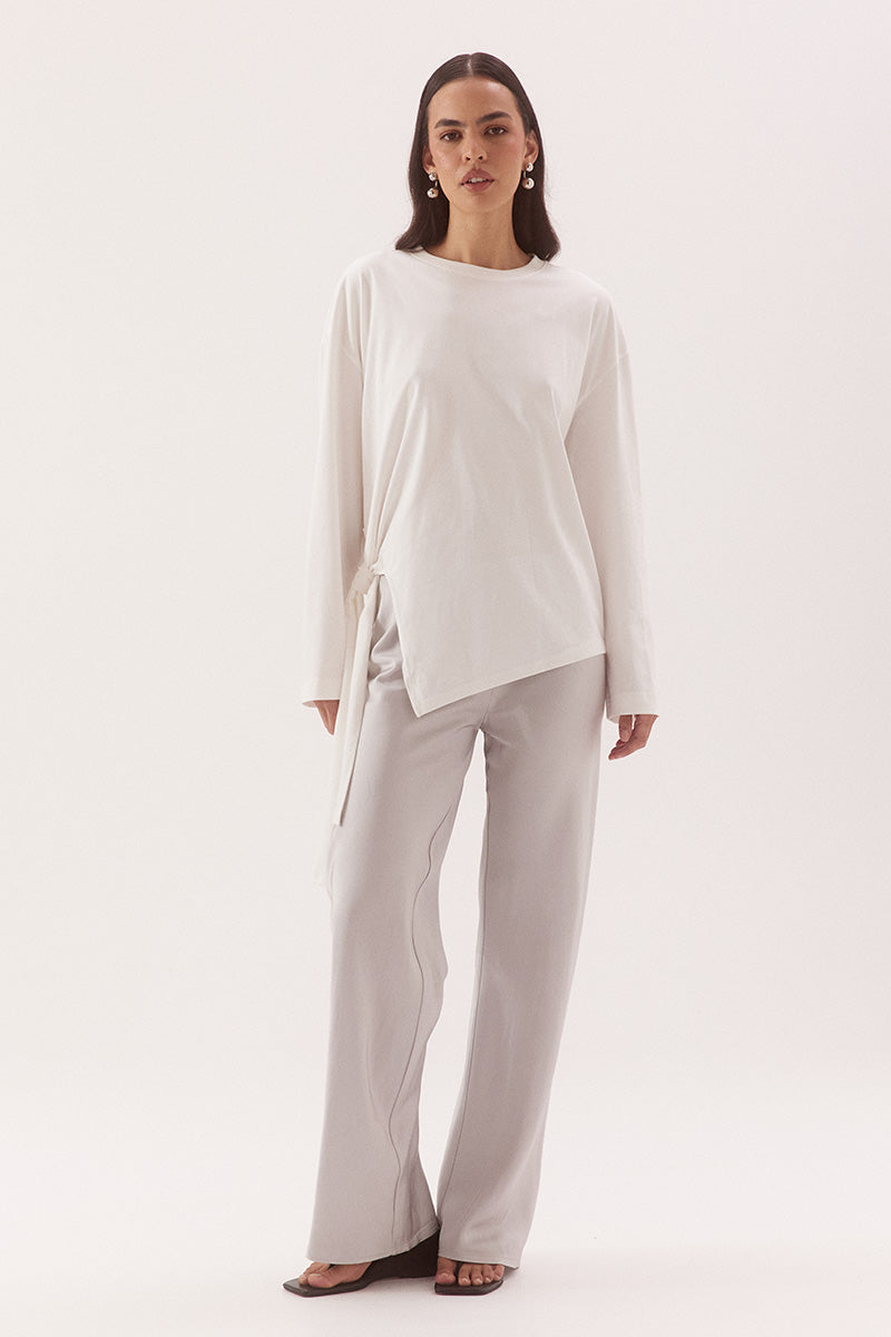 Women's oversized long sleeve cotton tee with dropped shoulders, crew neck, tie-side detail, and relaxed fit. Model wears size 8 and is 178cm tall.