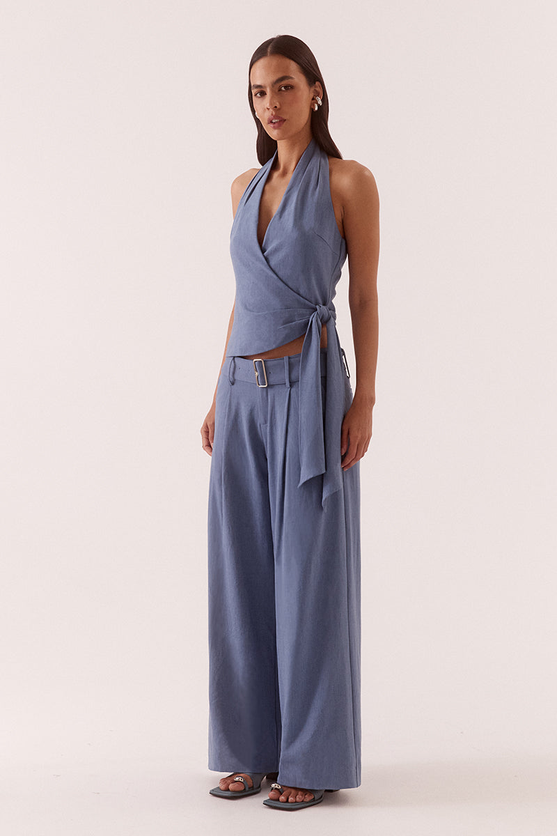 Women’s halter neck top in stretch rayon blend with wrap design, asymmetric hem, sash detail, elasticated back, and side zip closure.