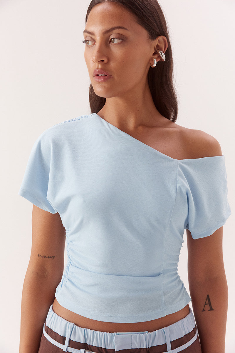 Textured mesh off shoulder top with asymmetric neckline, gathered waist, short sleeves and versatile shoulder styling