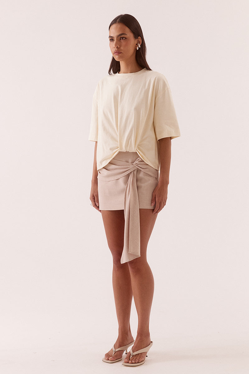 Women’s oversized cotton tee with dropped shoulders, crew neck, mid-length sleeves, and tucked front detail creating a shaped hem.
