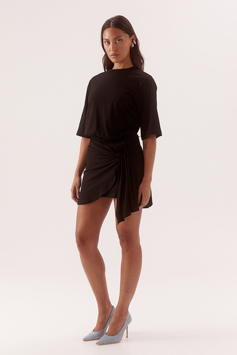 - Cotton fabrication
- Relaxed fit T- shirt mini dress
- Cinched waist
- Crew neck
- Elbow length sleeve
- Skirt overlayer has pleats pulled to one side and held by a silver metal rod
- Asymmetric hem
- Invisible zipper at side
- Length: 86cm