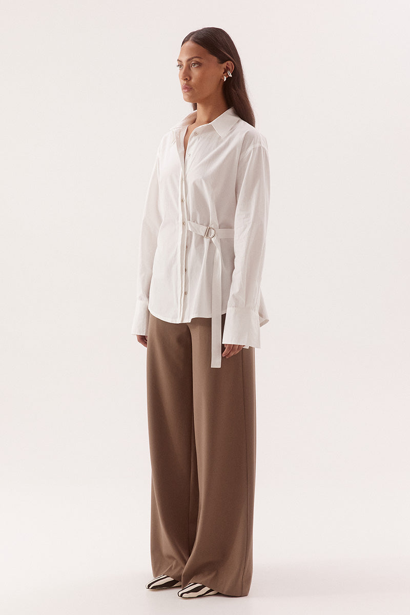 Women's relaxed fit cotton long sleeve shirt with dropped shoulders, silver metal buttons, adjustable belt detail, and side split shirtmaker hem.