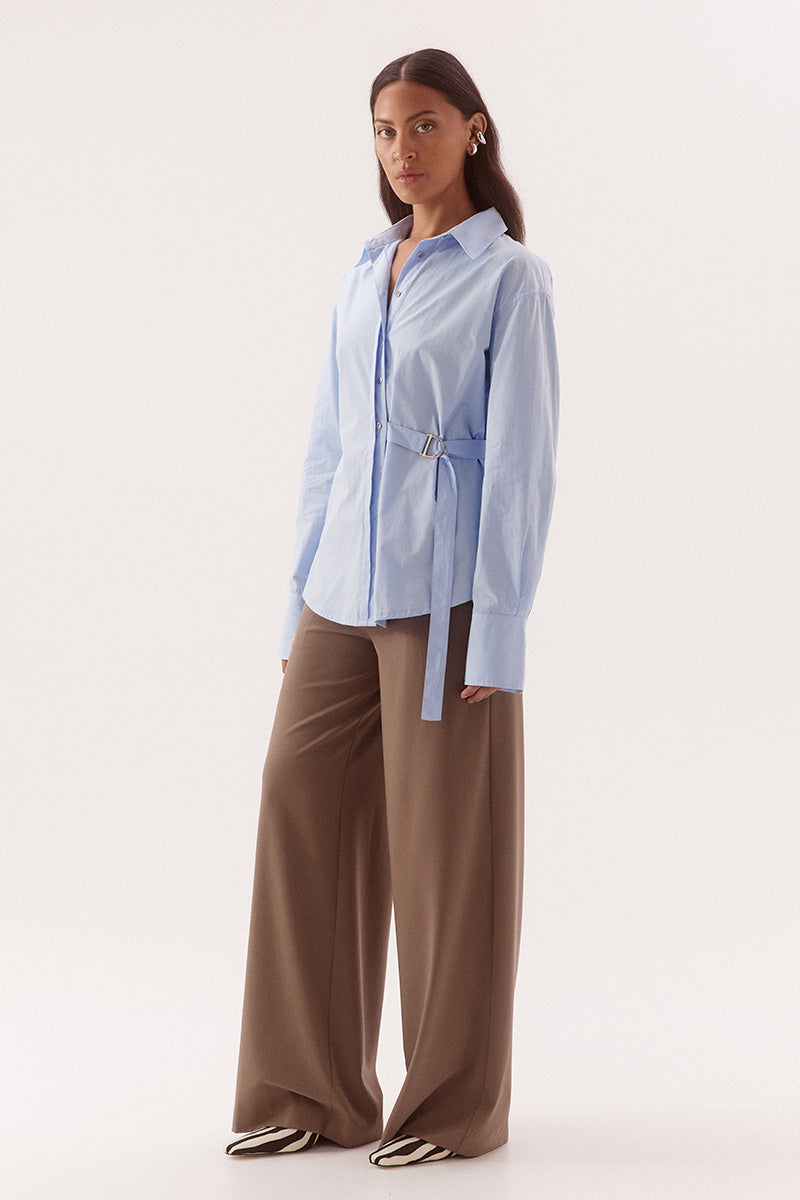Women's relaxed fit cotton long sleeve shirt with dropped shoulders, silver metal buttons, adjustable belt detail, and side split shirtmaker hem.